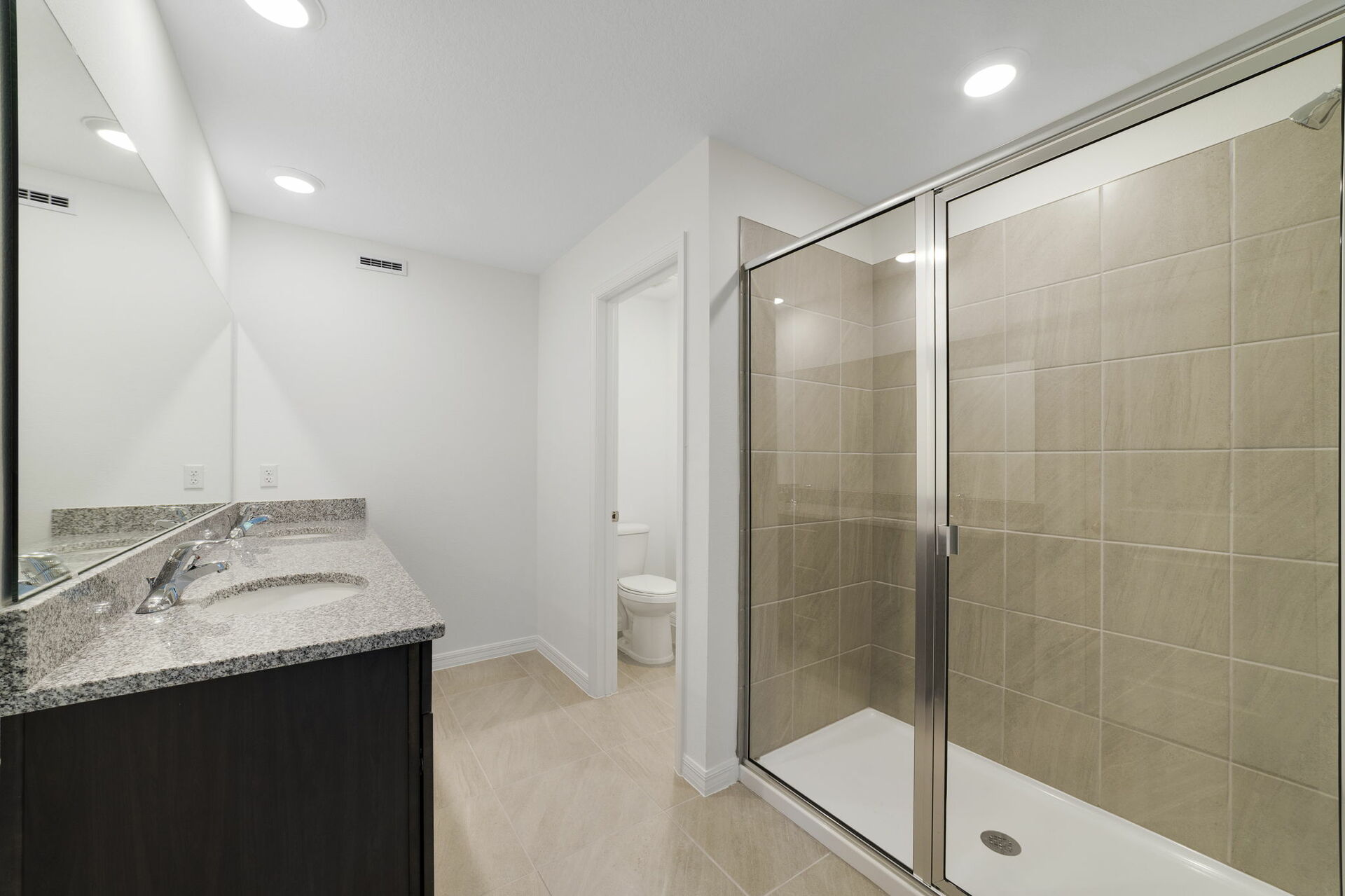 dual sink vanity with water closet and shower