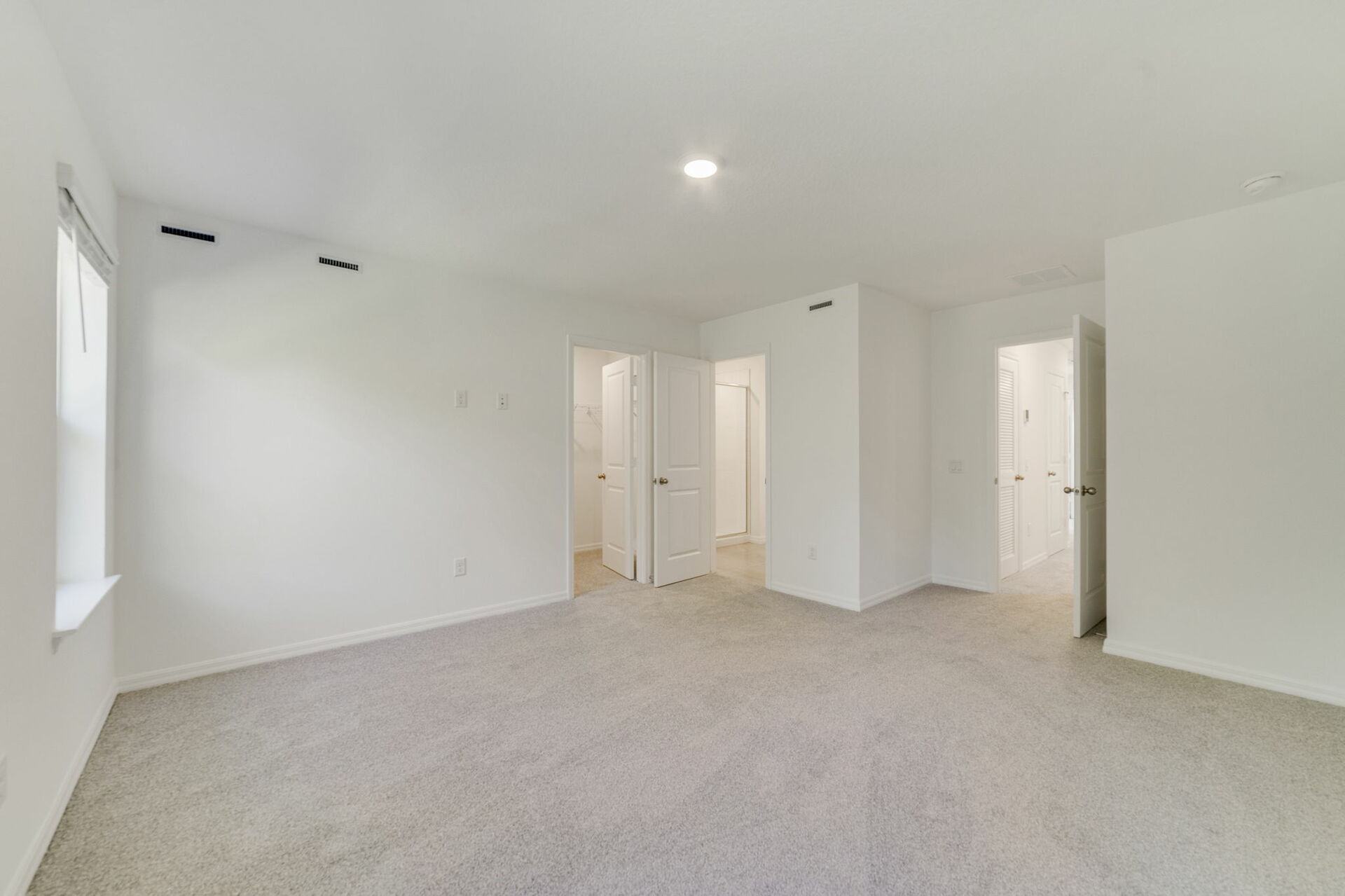 primary bedroom with view of multiple window and access to primary bathroom