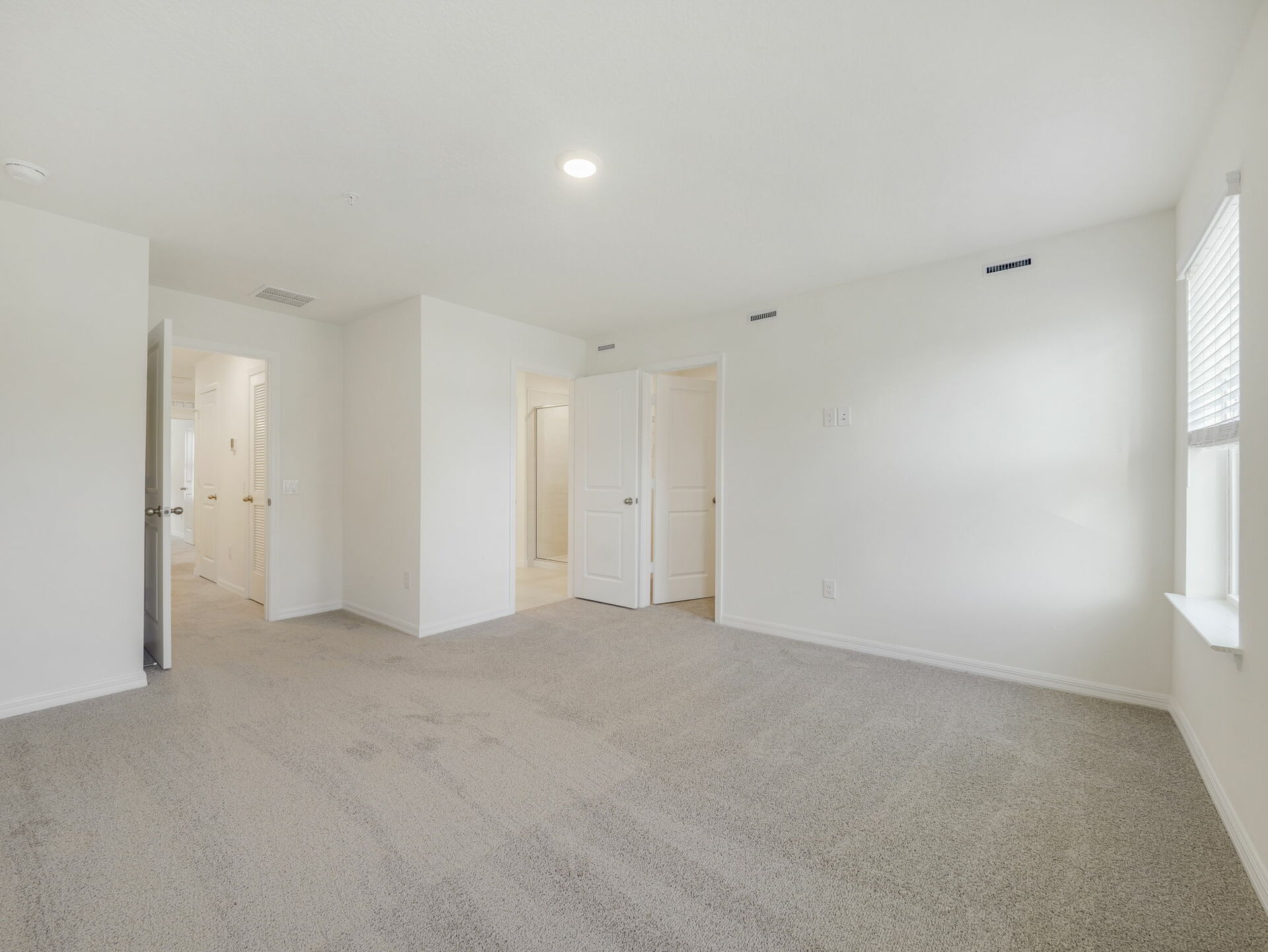bedroom with carpet throughout and large windows 