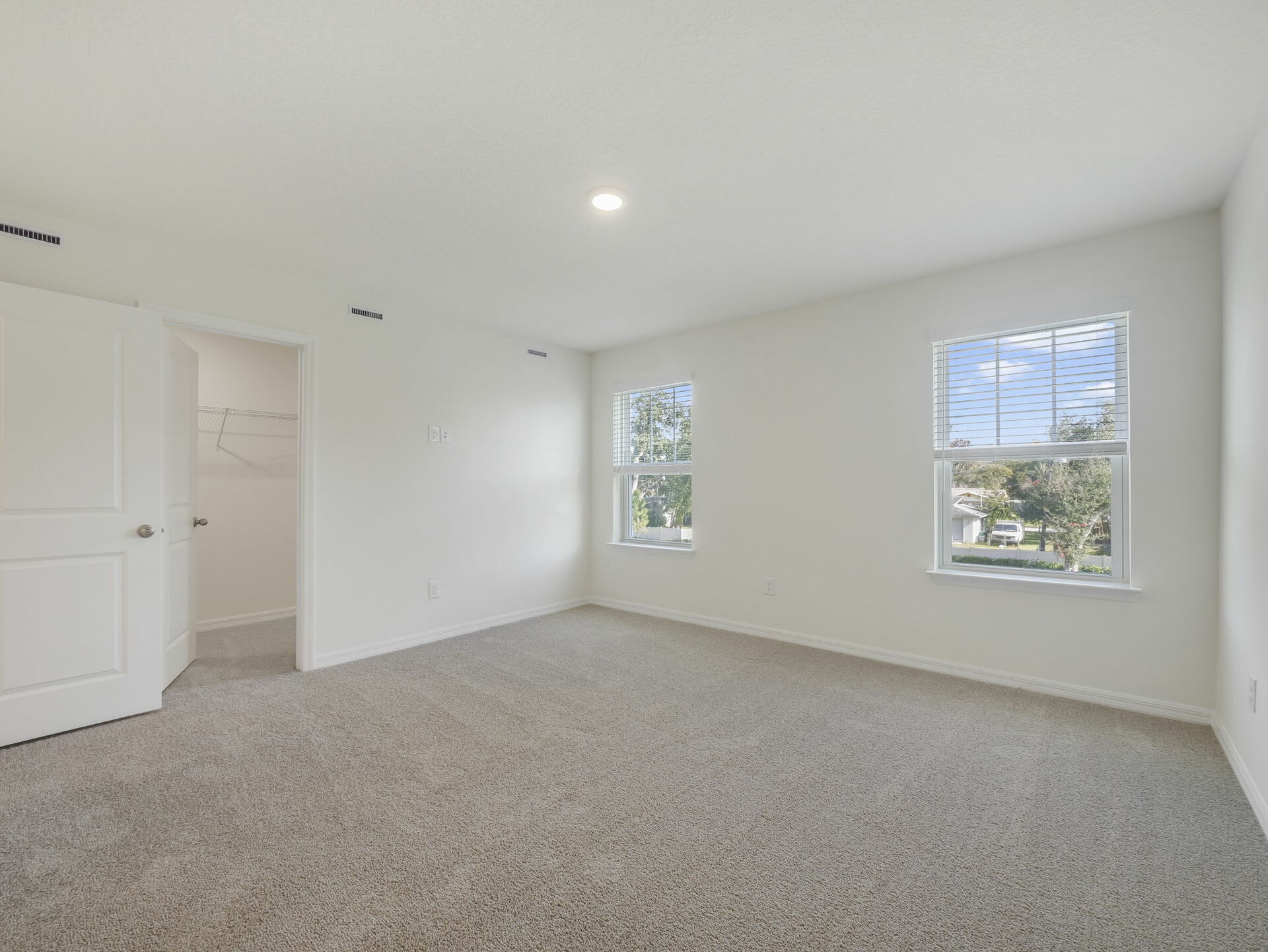 bedroom with carpet throughout and large windows 