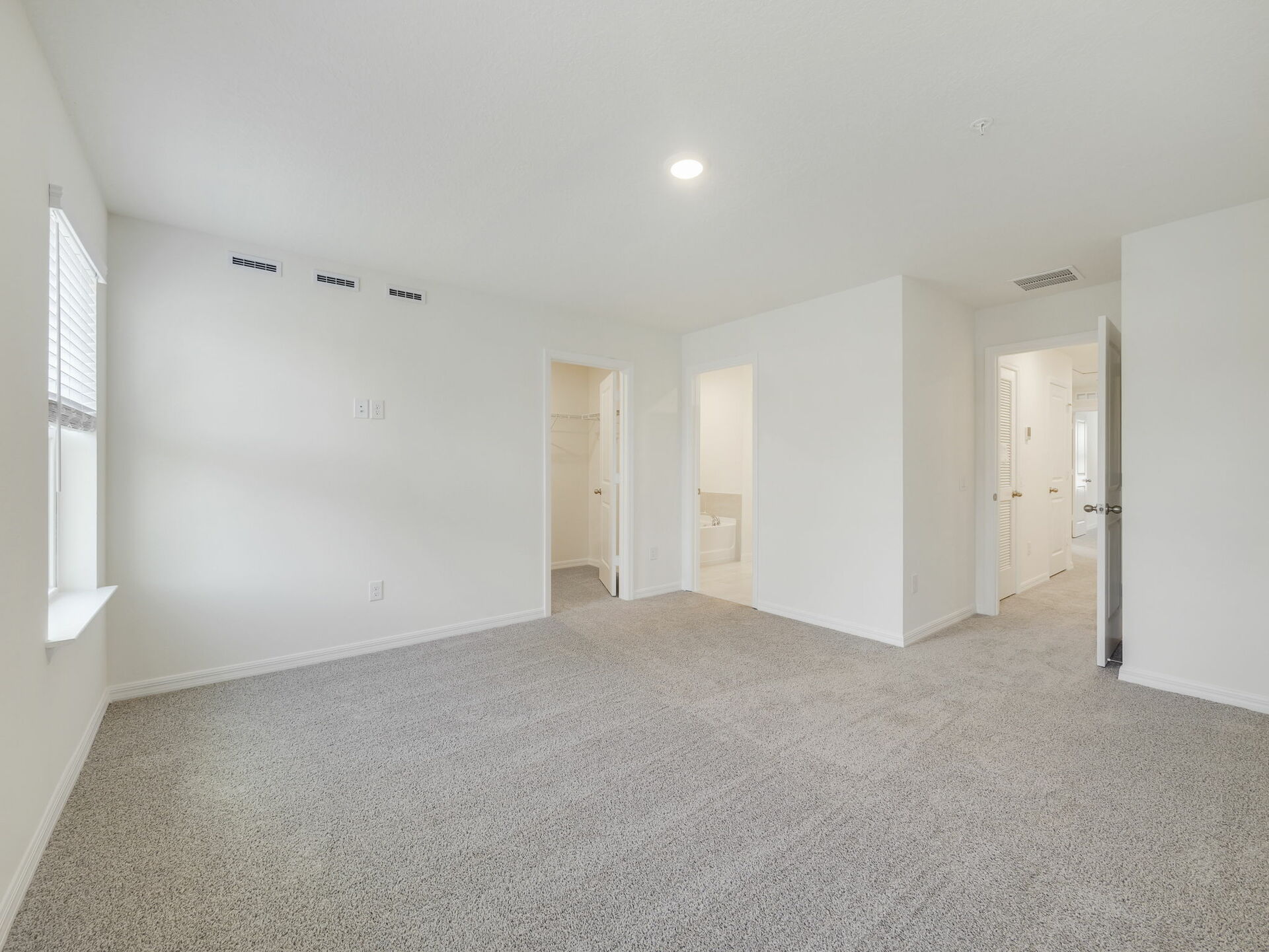 bedroom with carpet throughout and large windows