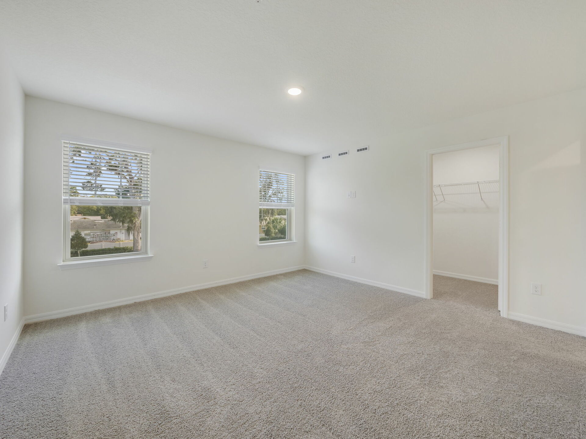 bedroom with carpet throughout and large windows