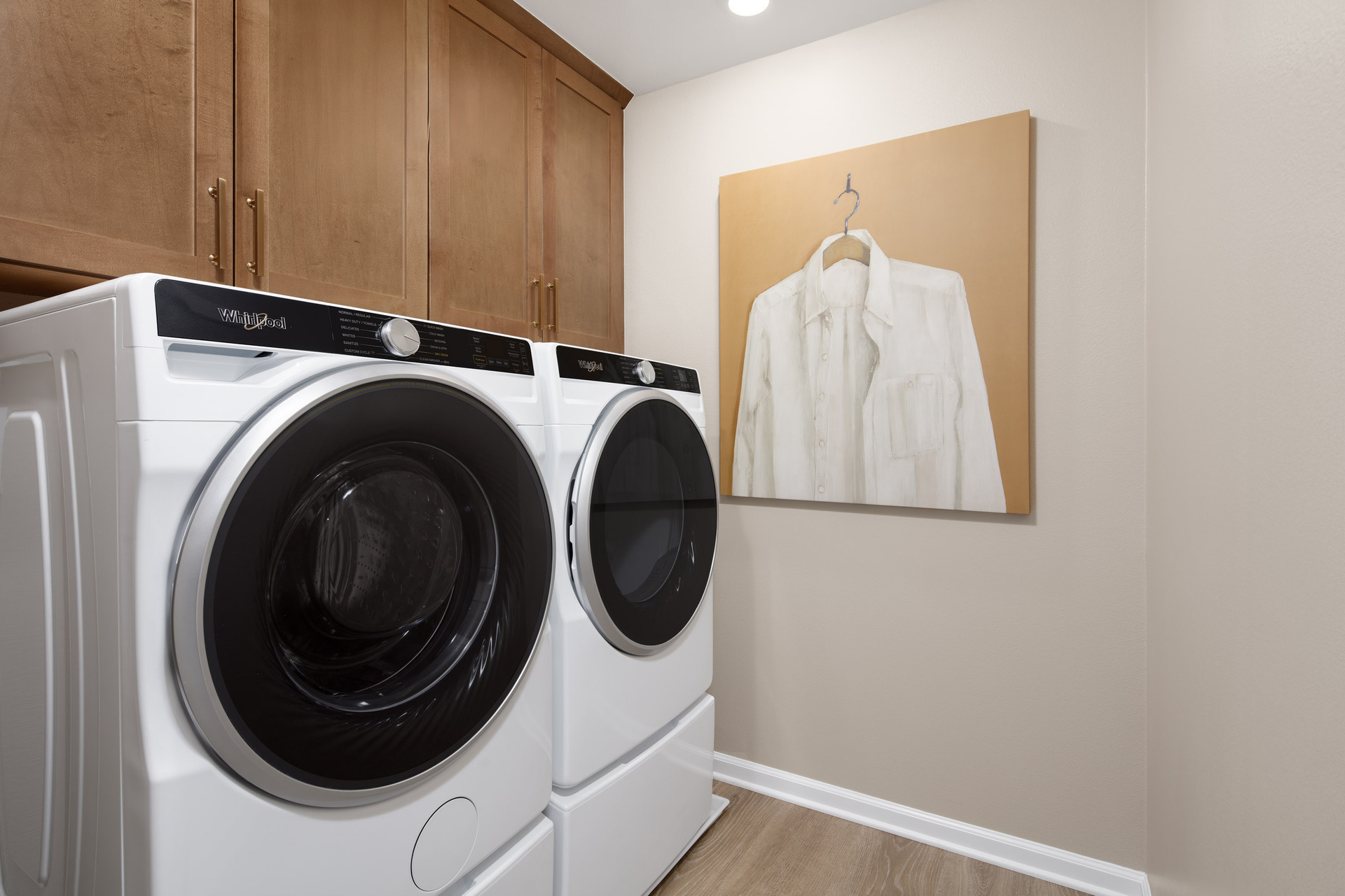 laundry room with neutral floors and storage