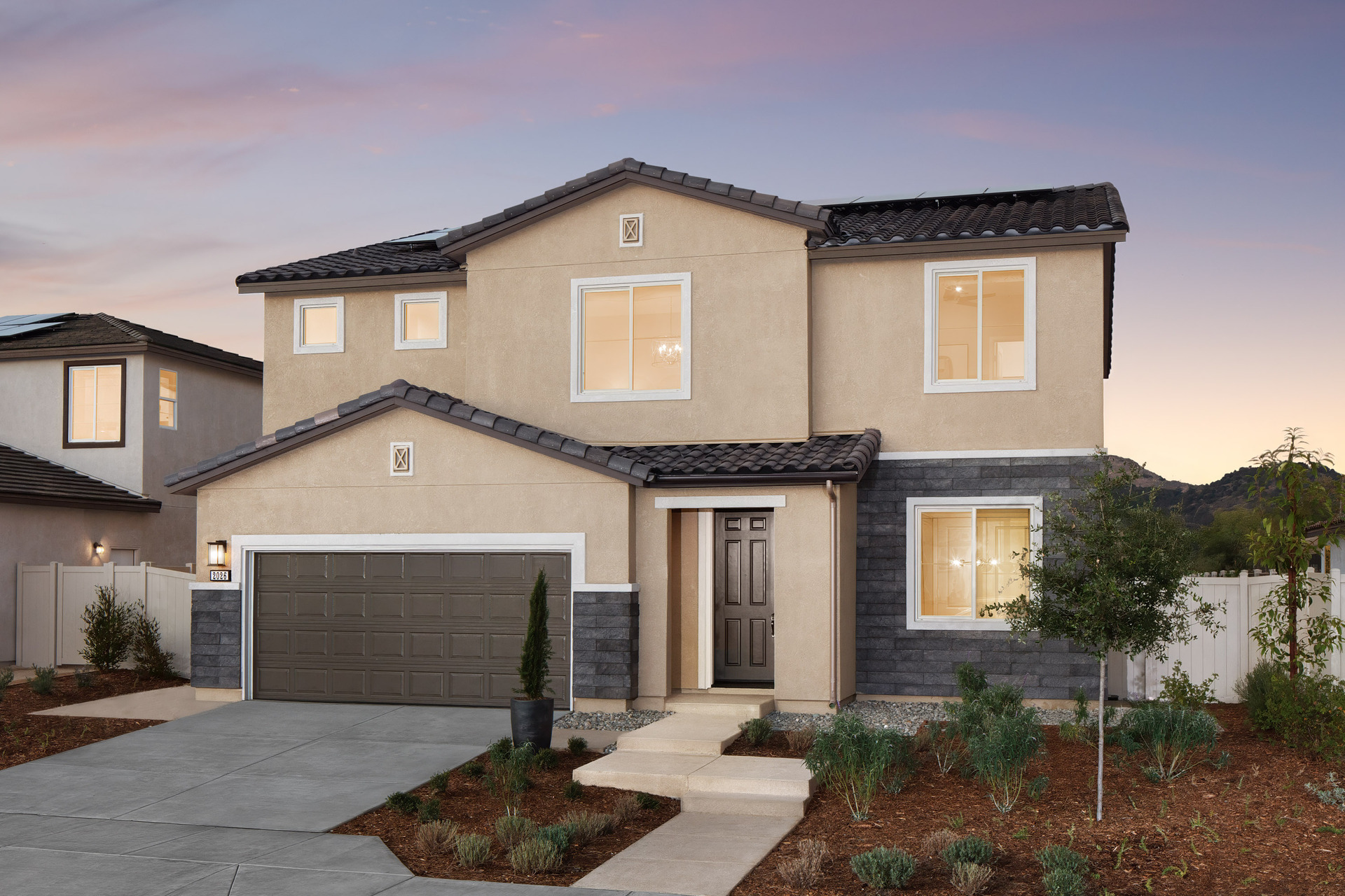 two-story exterior with a brown windowless garage and dark grey brick trim