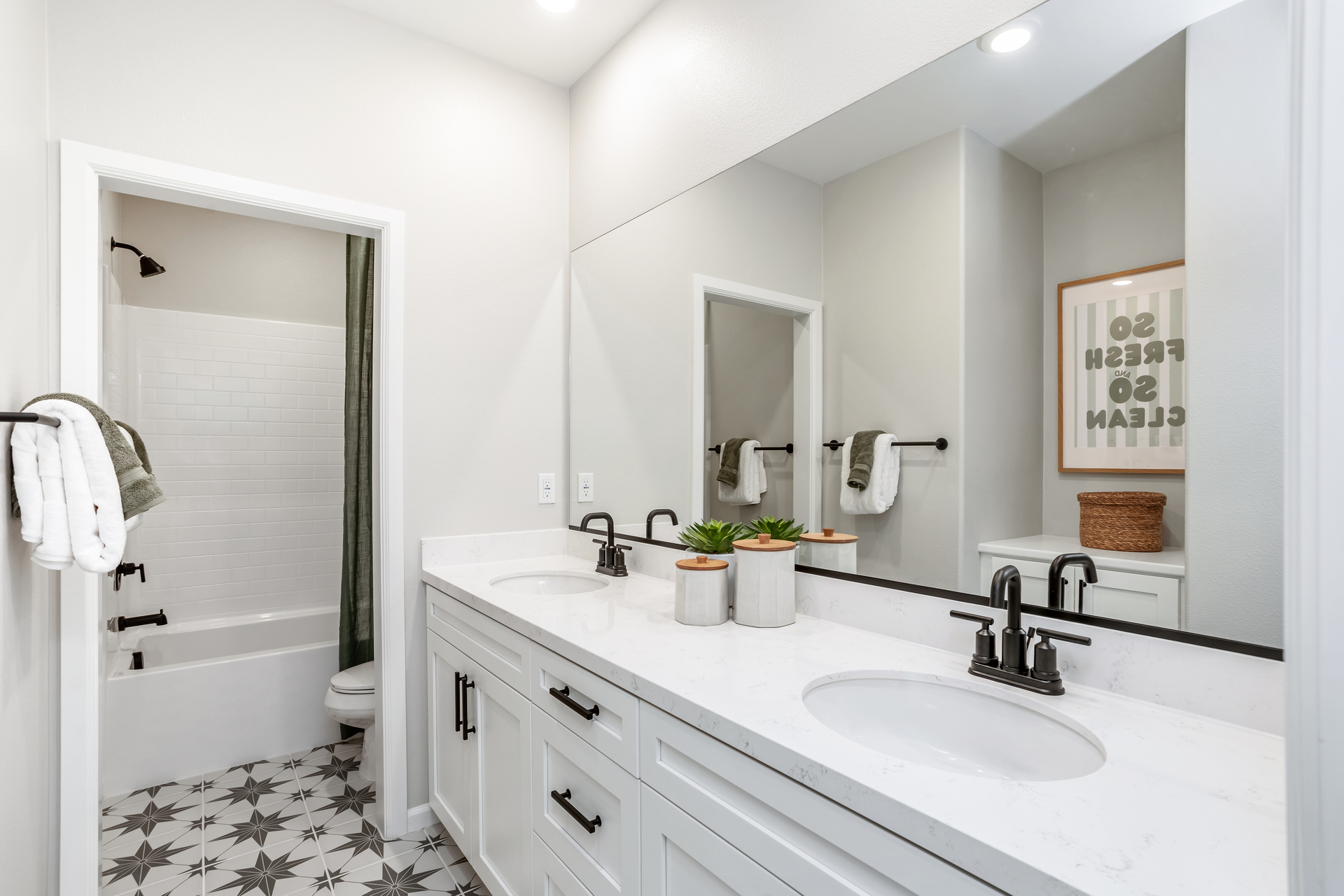 bathroom with tile floors and white cabinets