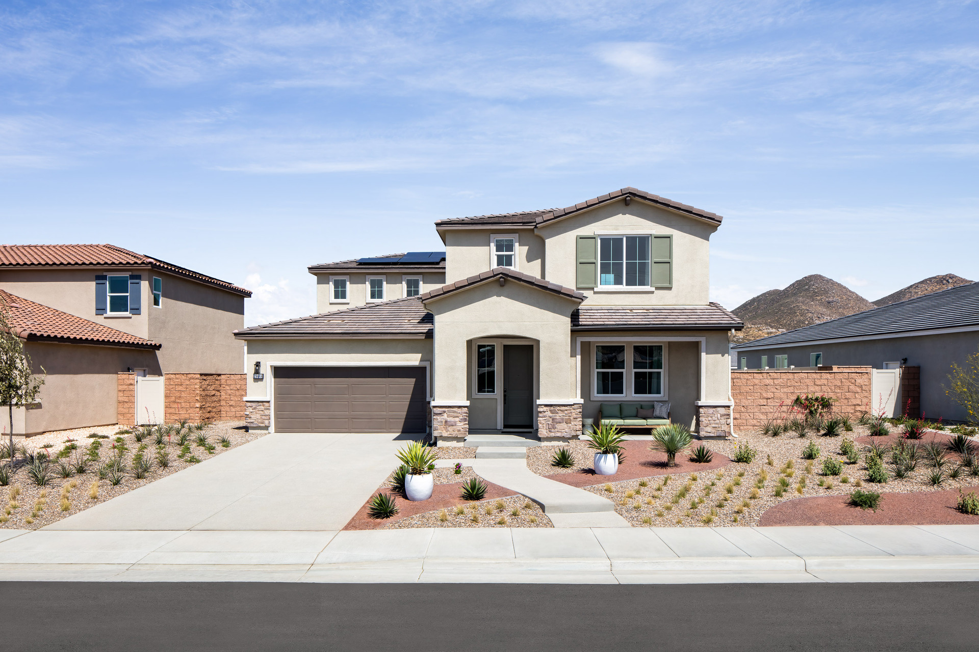 exterior of two story home with neutral paint and desert landscaping