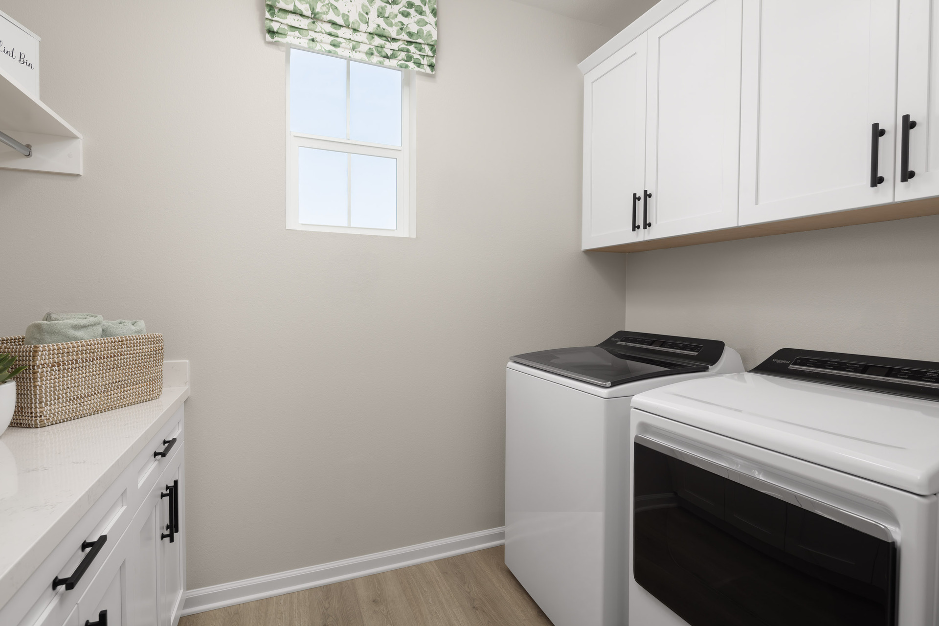 laundry room with neutral floors and window