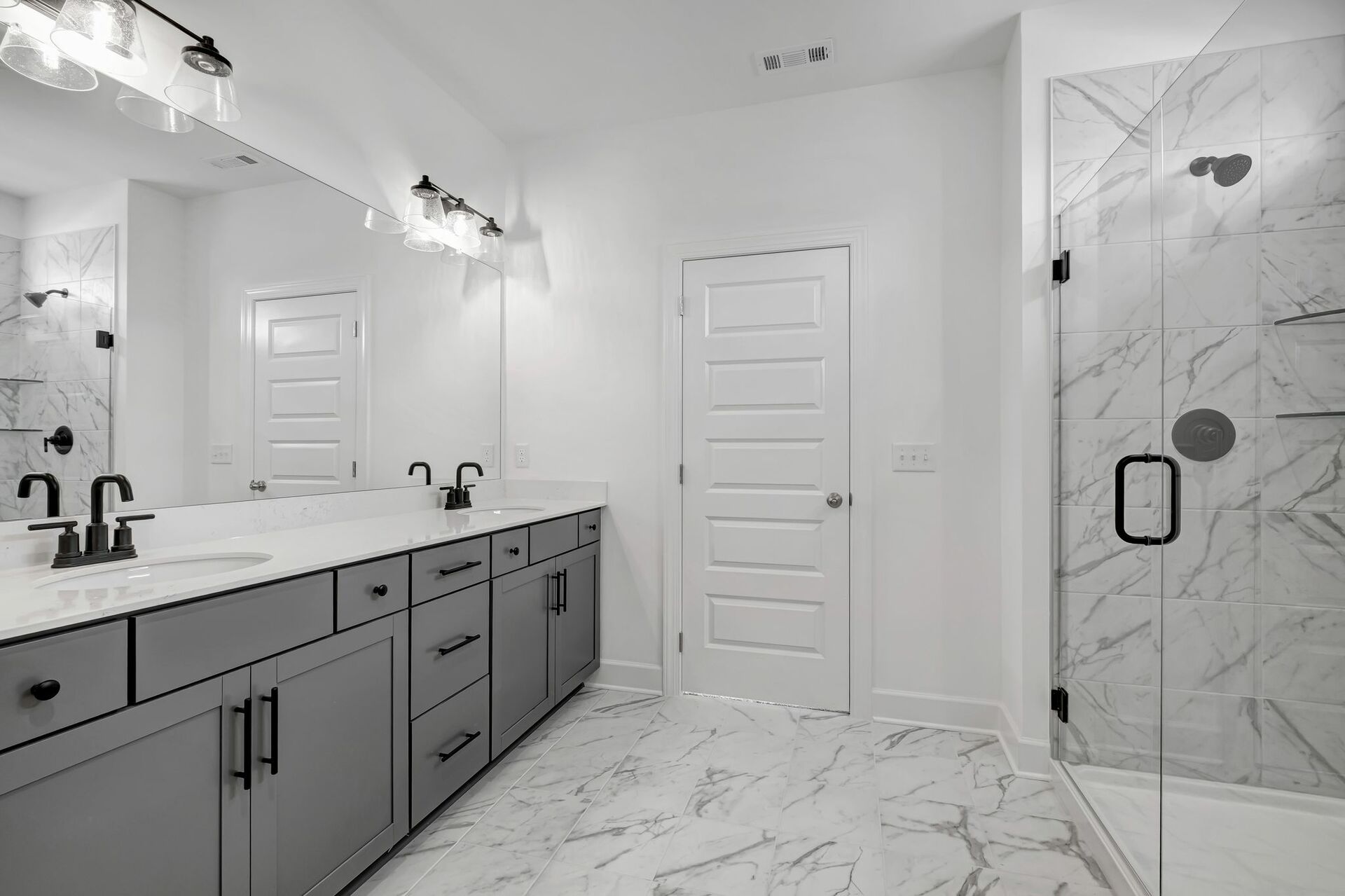 primary bathroom with double sink vanity, gray cabinets, and matte black fixtures