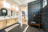 primary bathroom with black tile and enlarged glass shower