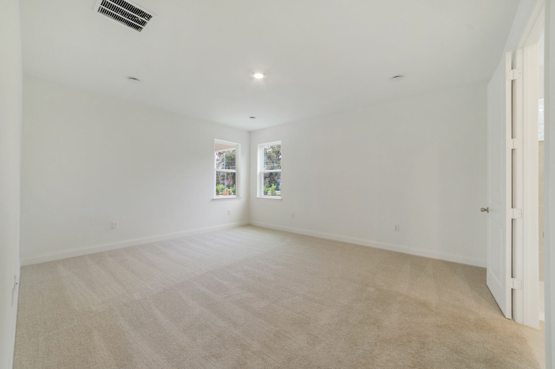 primary bedroom with carpet and access to the bathroom