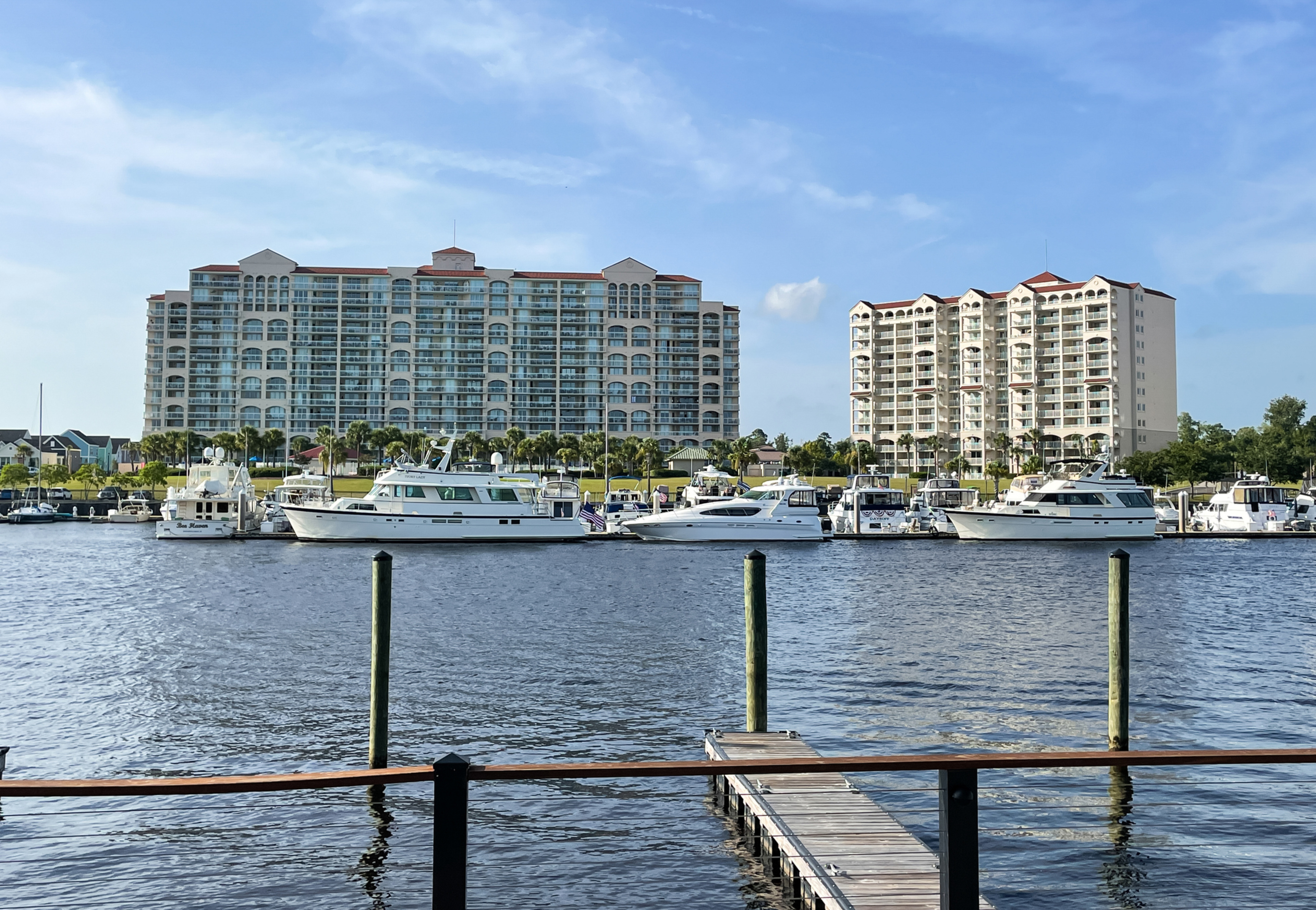 Large boats docked in the water beside waterfront condos, showcasing the perfect blend of coastal living and marina lifestyle