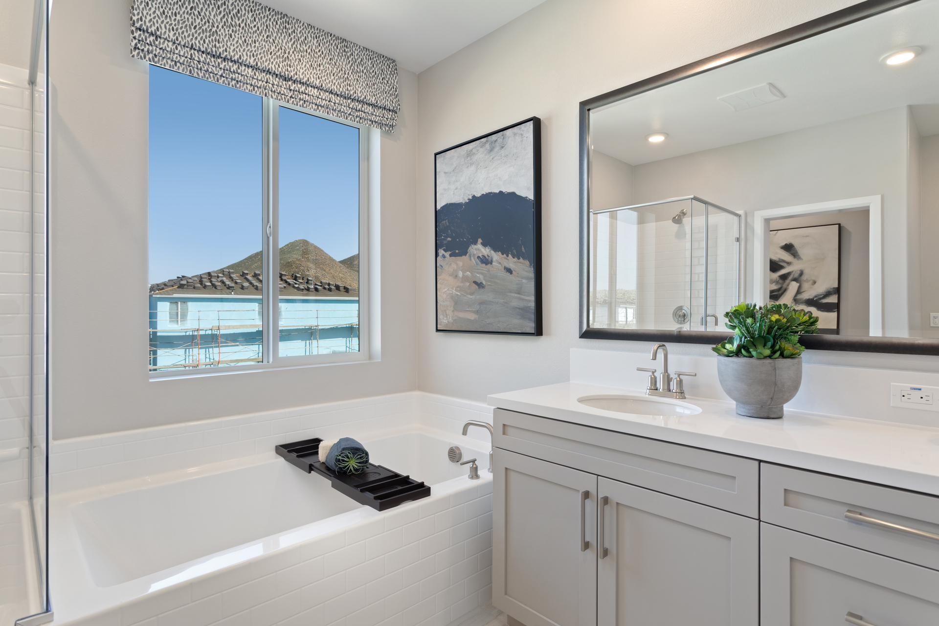 primary bathroom with large window and white countertops
