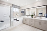 primary bathroom with white countertops and large window