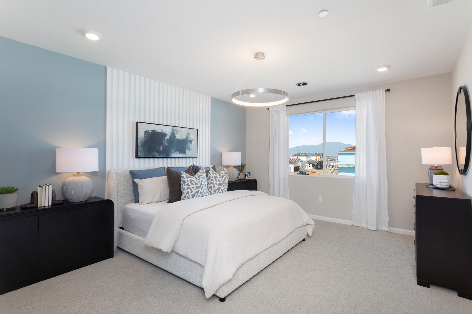 primary bedroom with large window and neutral floors