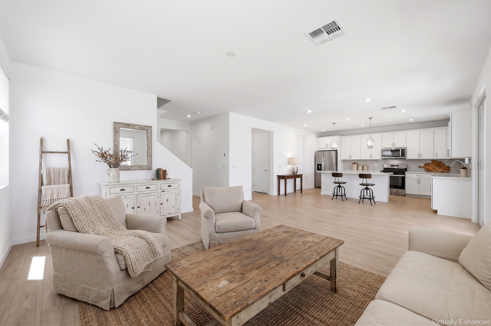 open-concept space with a large white couch, accent chairs, and a wooden rustic coffee table 