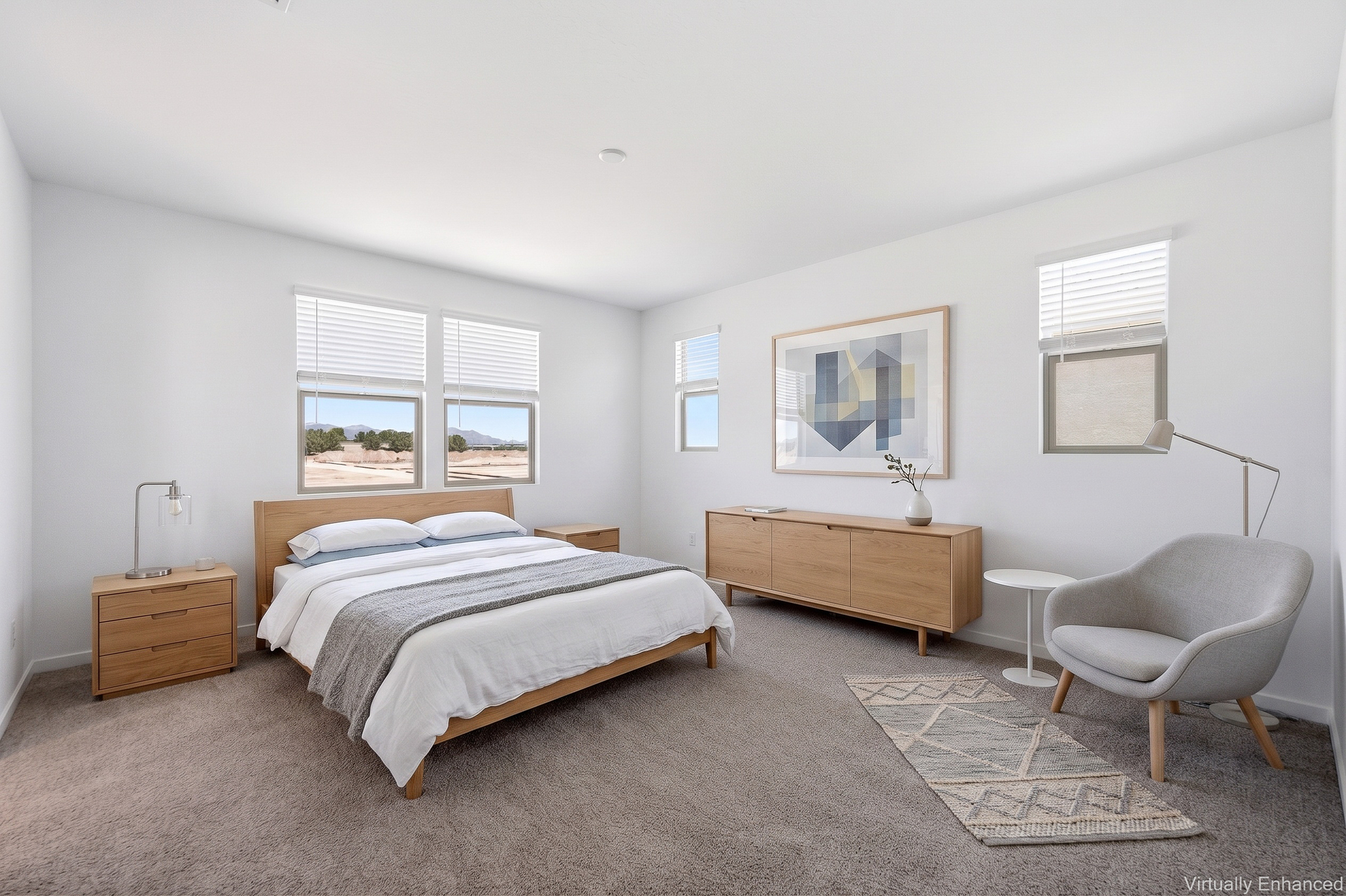 spacious bedroom with a king-sized bed with an oak bedframe, oak nightstands, and a grey accent chair