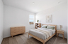 bedroom with a full-sized bed with an oak bedframe, oak nightstand, and a bookshelf