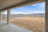 spacious dirt backyard with a concrete block wall