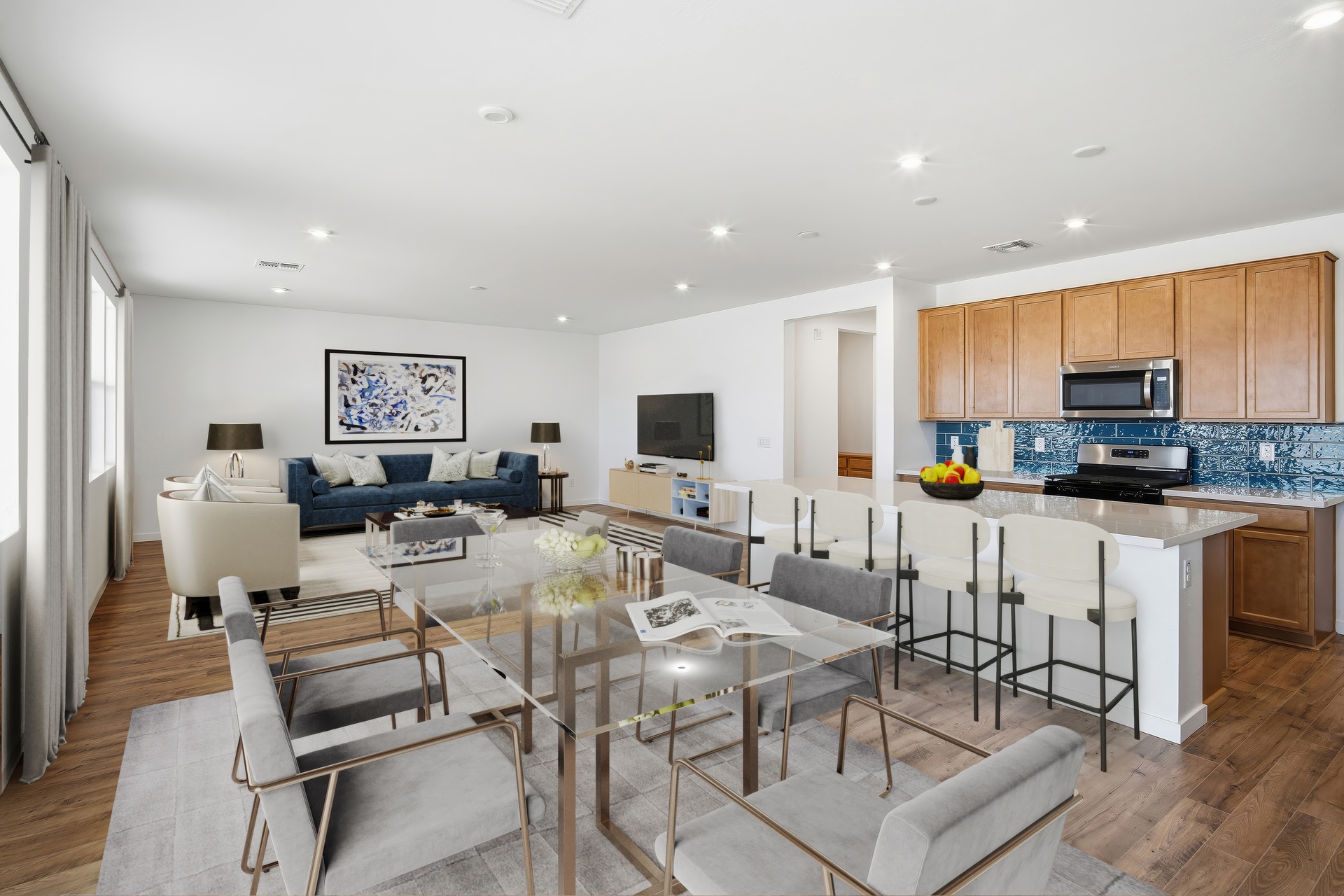 open-concept space with a glass dining table, grey chairs, and grey rug