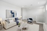 open-concept space with a large white couch, white coffee table, and blue accent chair