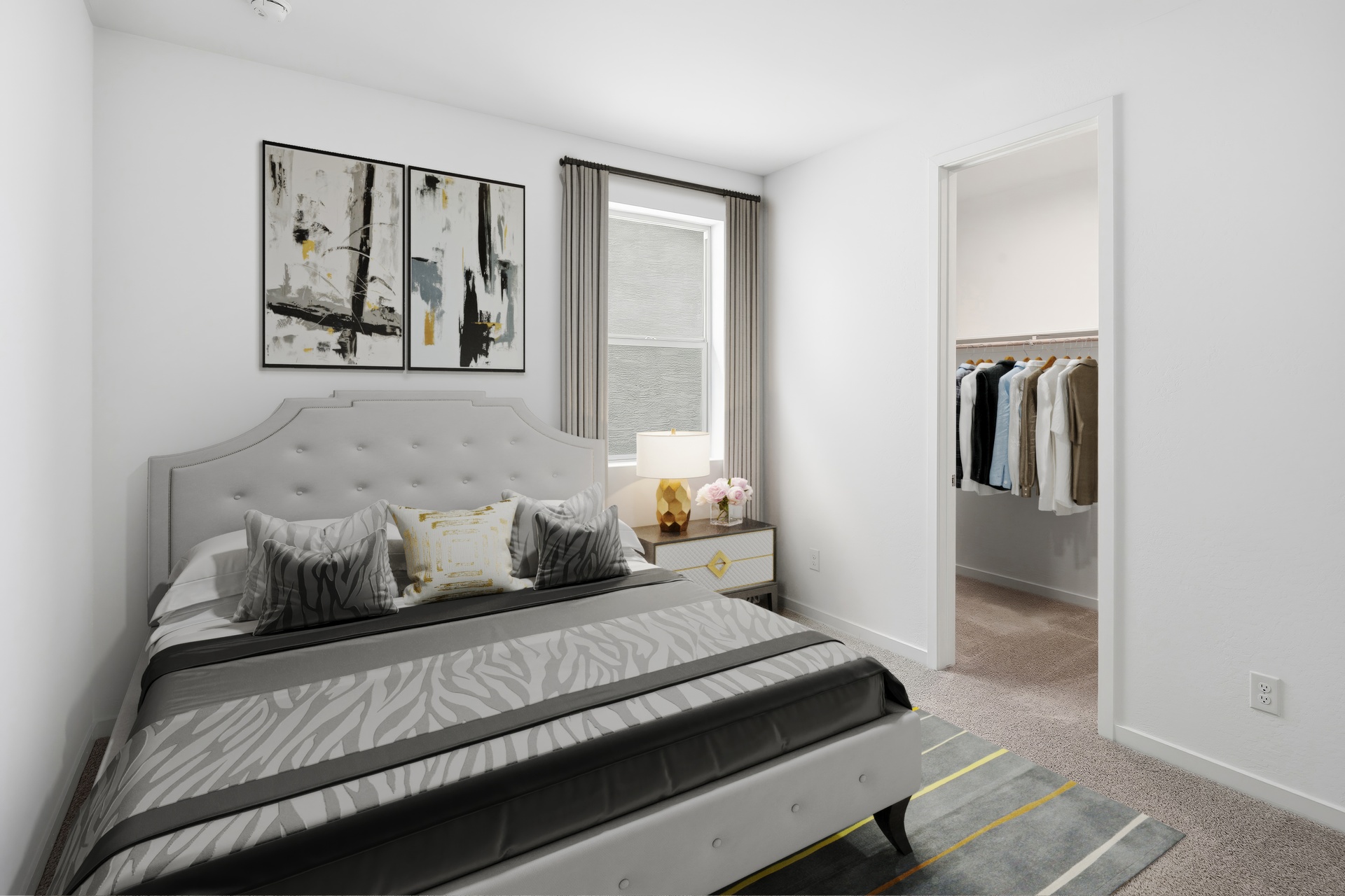 bedroom with a large bed, grey zebra print covers, and large grey rug