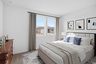 bedroom with a large bed, blue accent colors and a large brown dresser