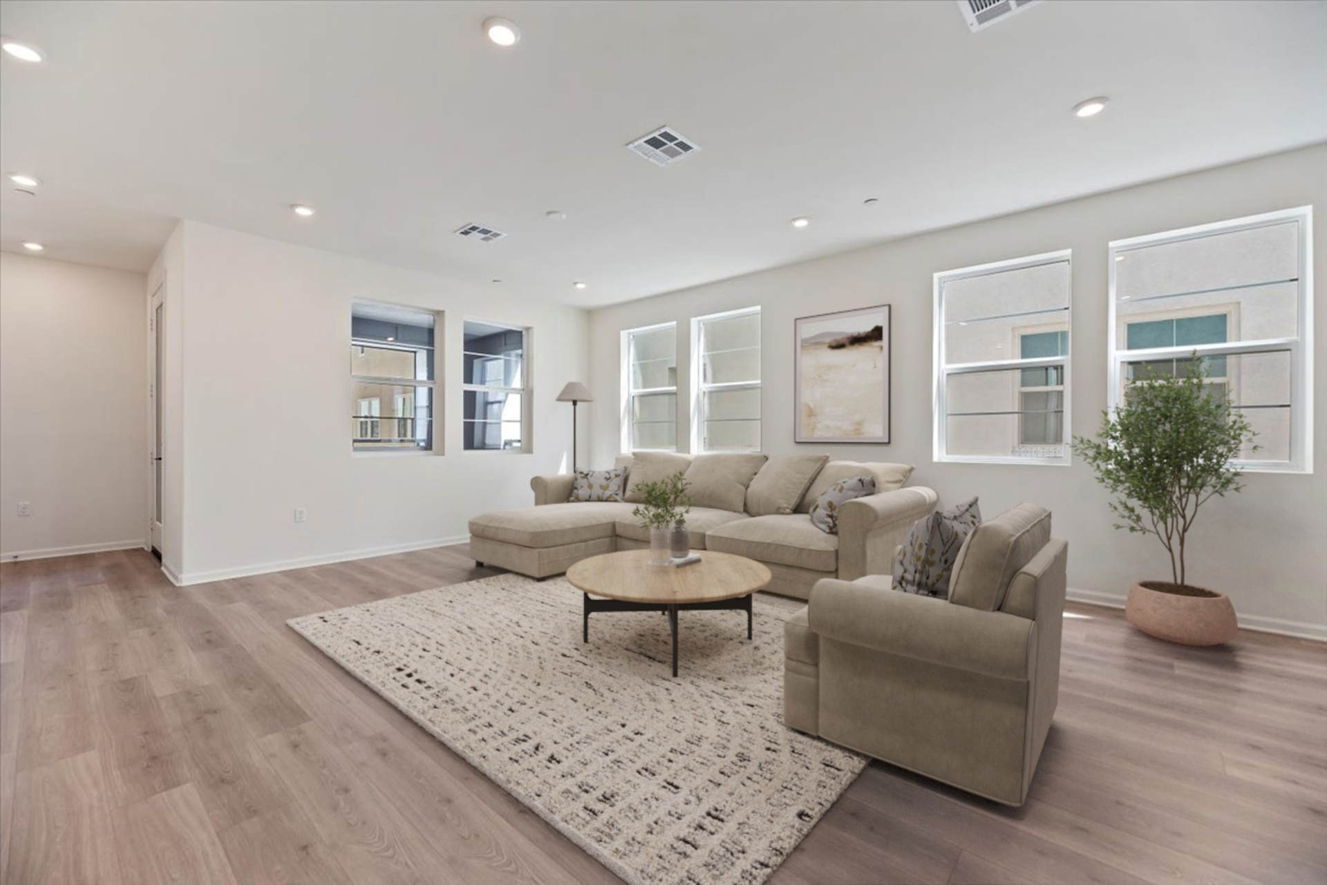 large room with a sectional sofa and white rug with a coffee table