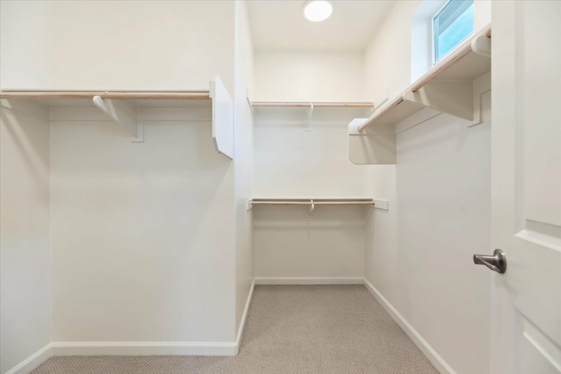 closet with shelves and racks for clothes