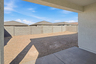 spacious dirt backyard with concrete block wall