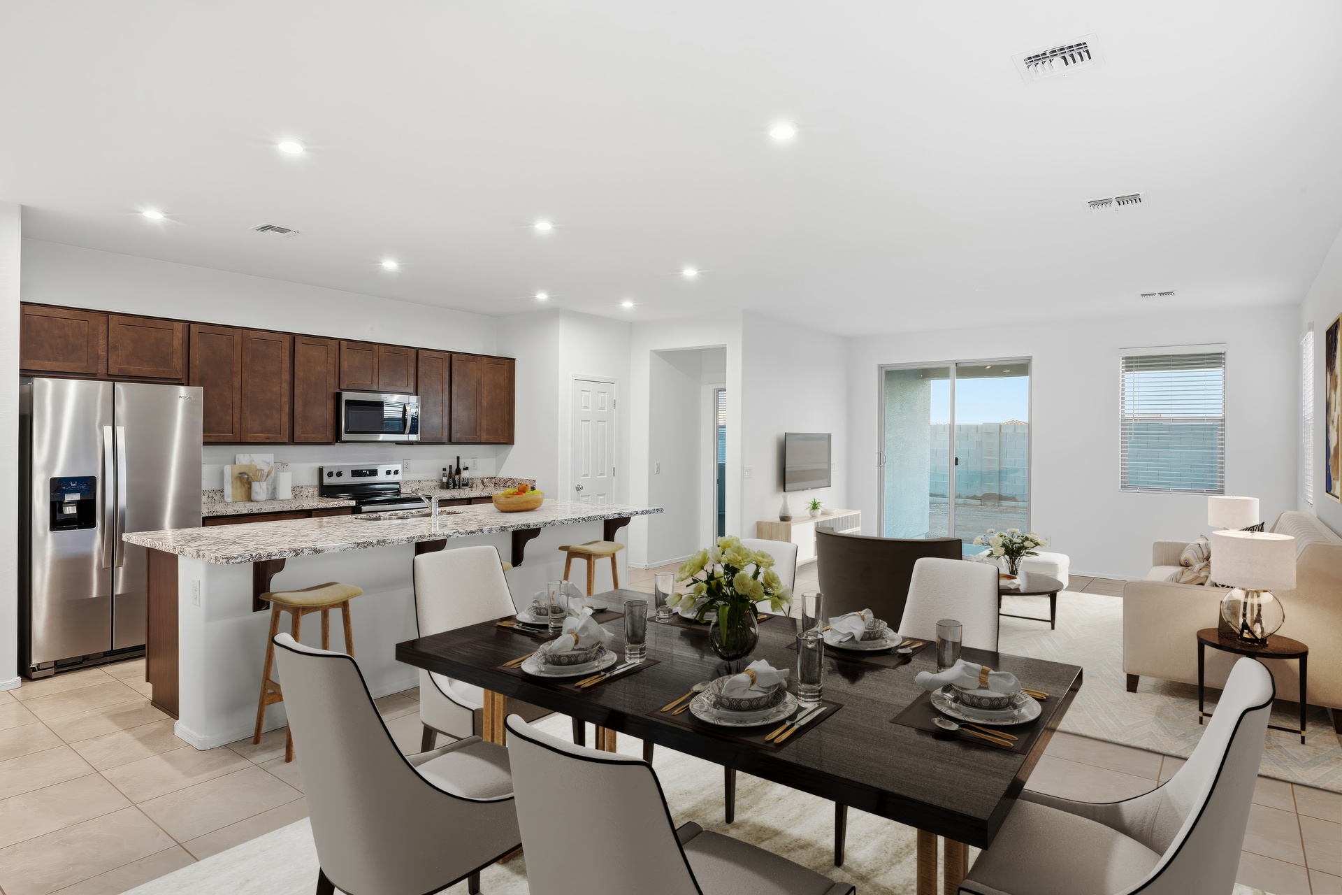 open-concept space with wooden dining table and white dining chairs