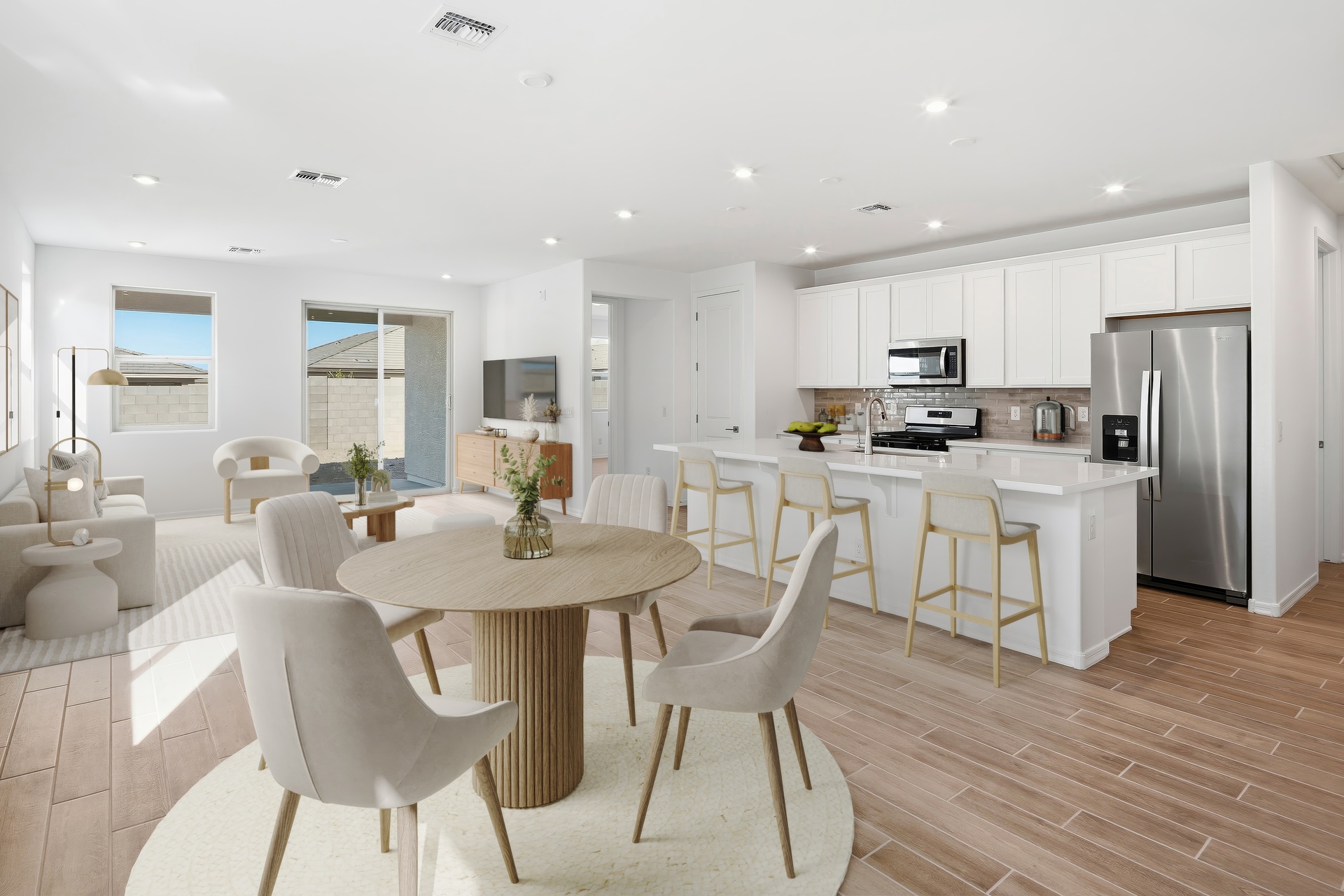 spacious dining room with a round wooden dining table and white chairs