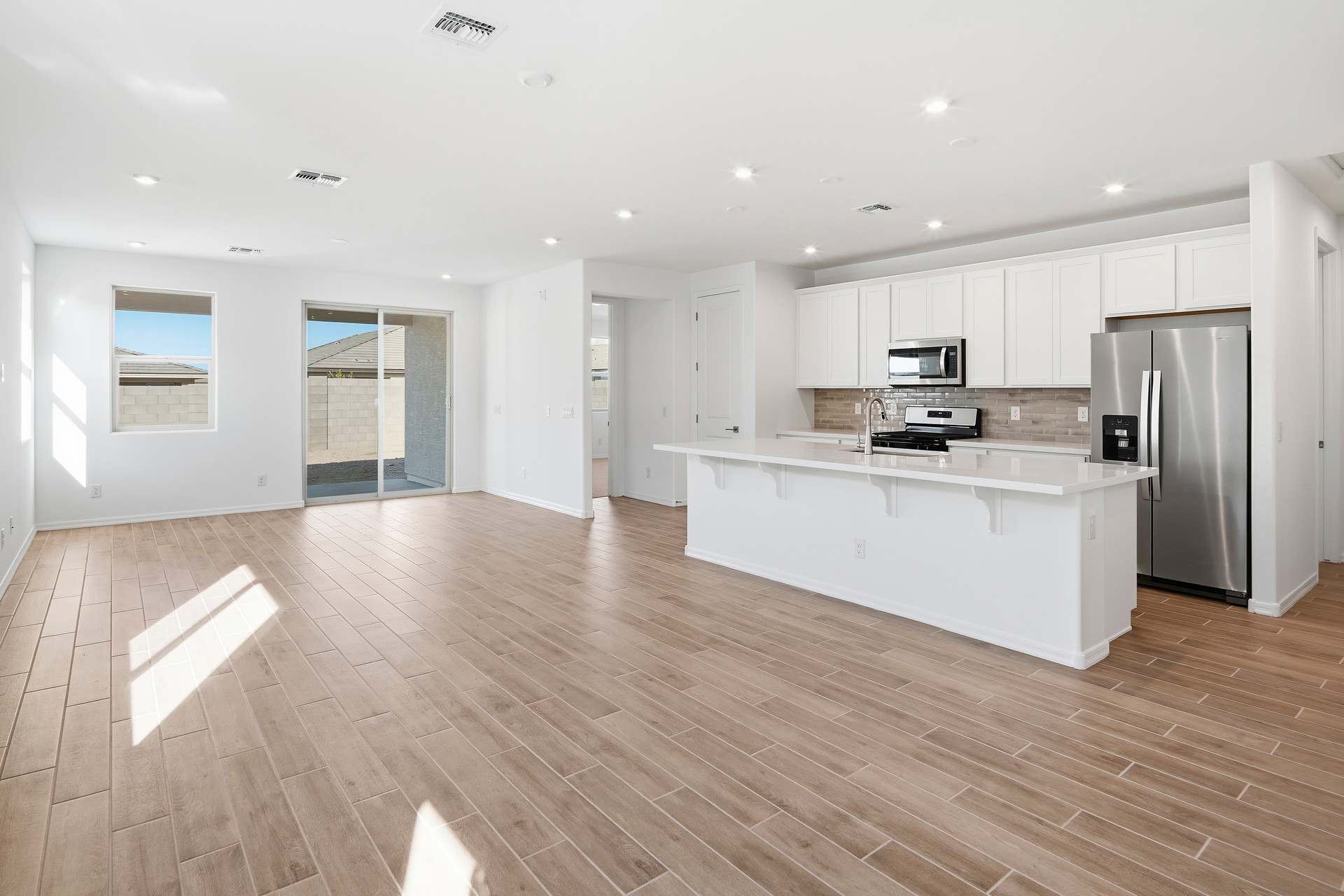 open-concept space with wood-like flooring and recessed lights