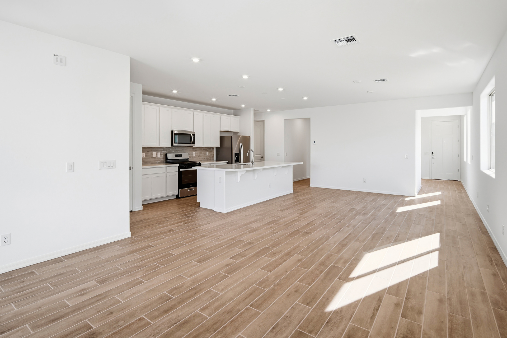 open-concept space with wood-like flooring and recessed lights