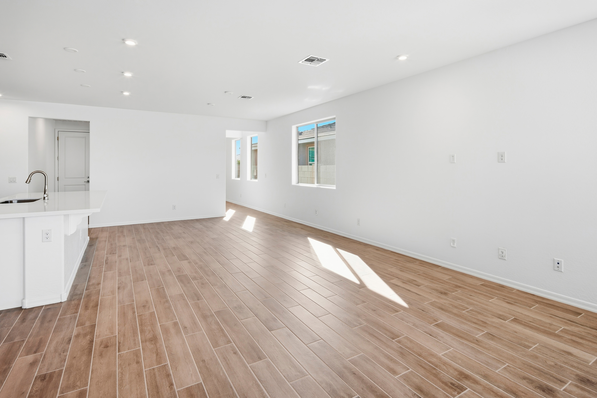 open-concept space with wood-like flooring and recessed lights