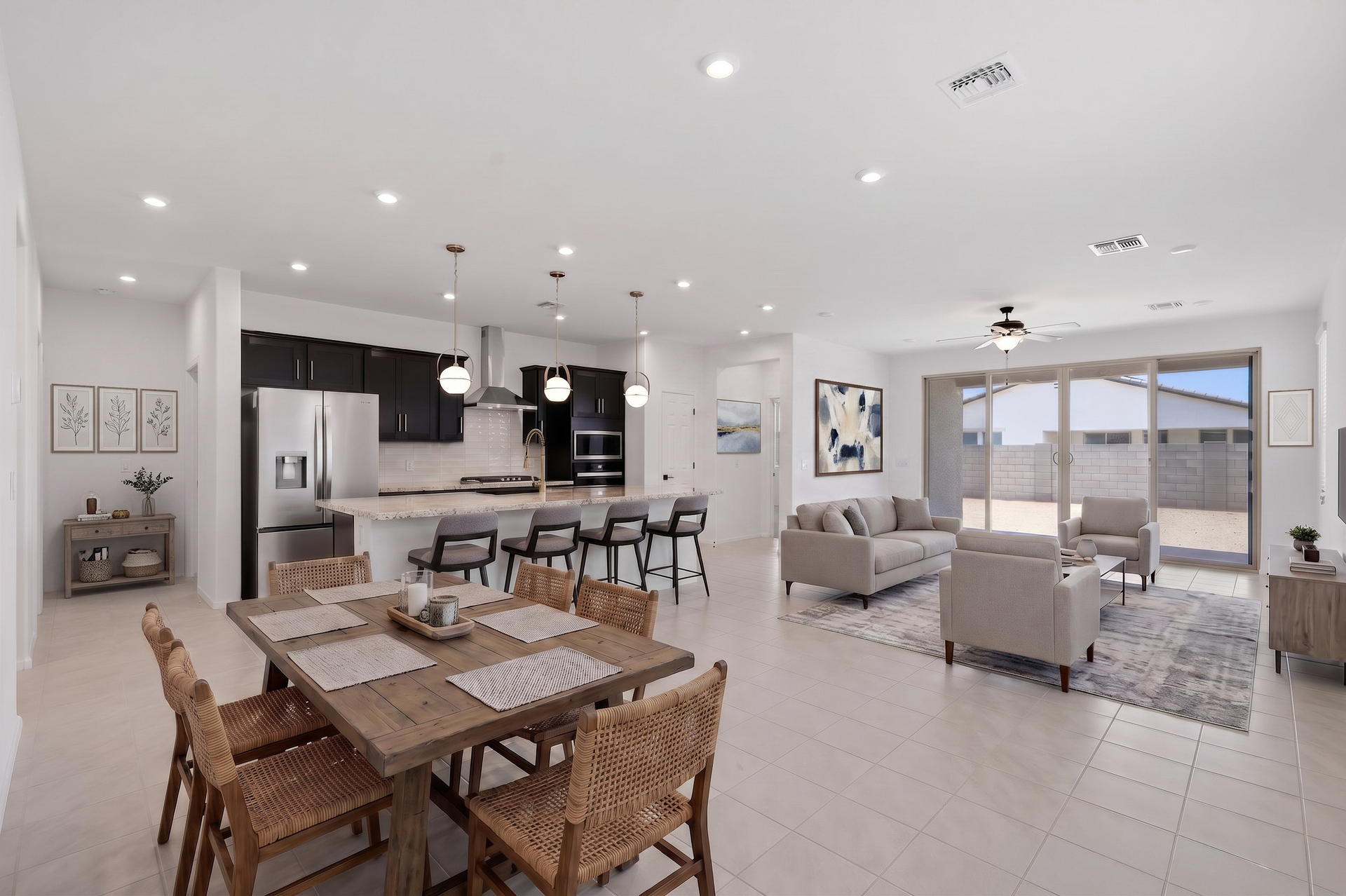 open-concept space with a wooden dining table, a large white couch, and grey barstools