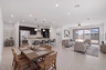 open-concept space with a wooden dining table, a large white couch, and grey barstools