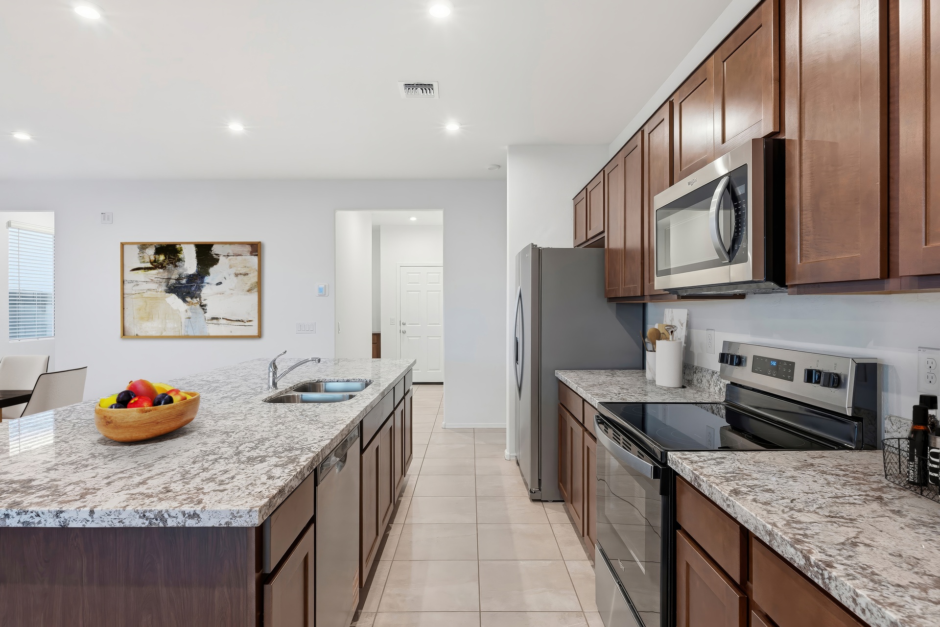 kitchen with granite countertops, stainless-steel appliances, and brown cabinets