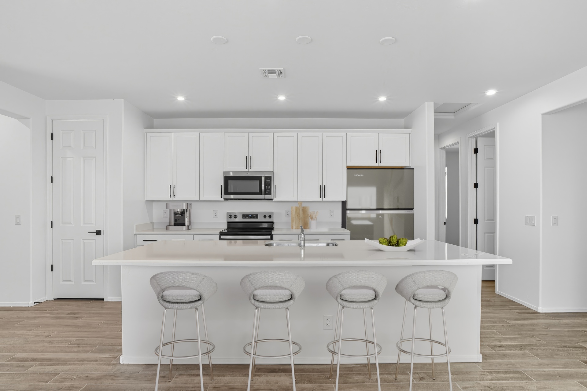 kitchen with white barstools, quartz countertops, and stainless-steel appliances