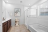 bathroom with a walk-in shower and soaking tub