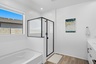 spacious bathroom with a walk-in shower with black hardware and soaking tub