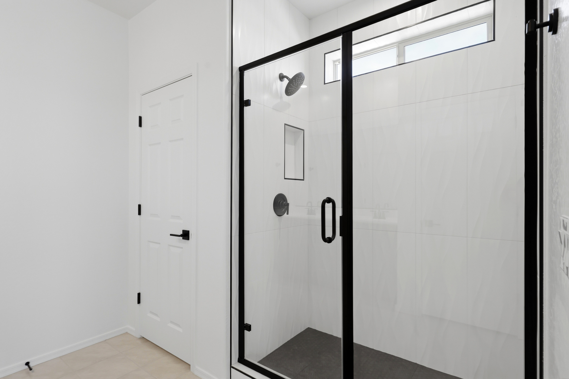 spacious bathroom with a large walk-in shower and black hardware