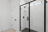 spacious bathroom with a large walk-in shower and black hardware