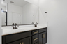 spacious bathroom with a double sink, black cabinets, and matte black faucets