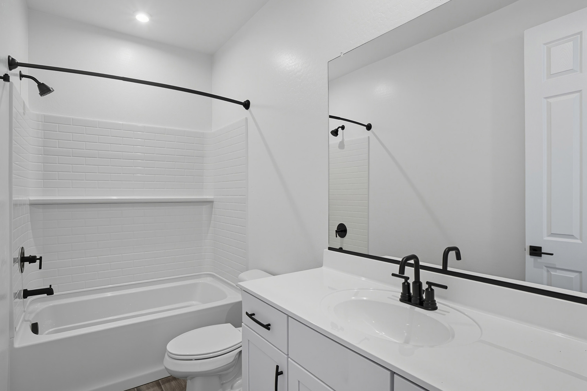 bathroom with white countertops and cabinets with black hardware