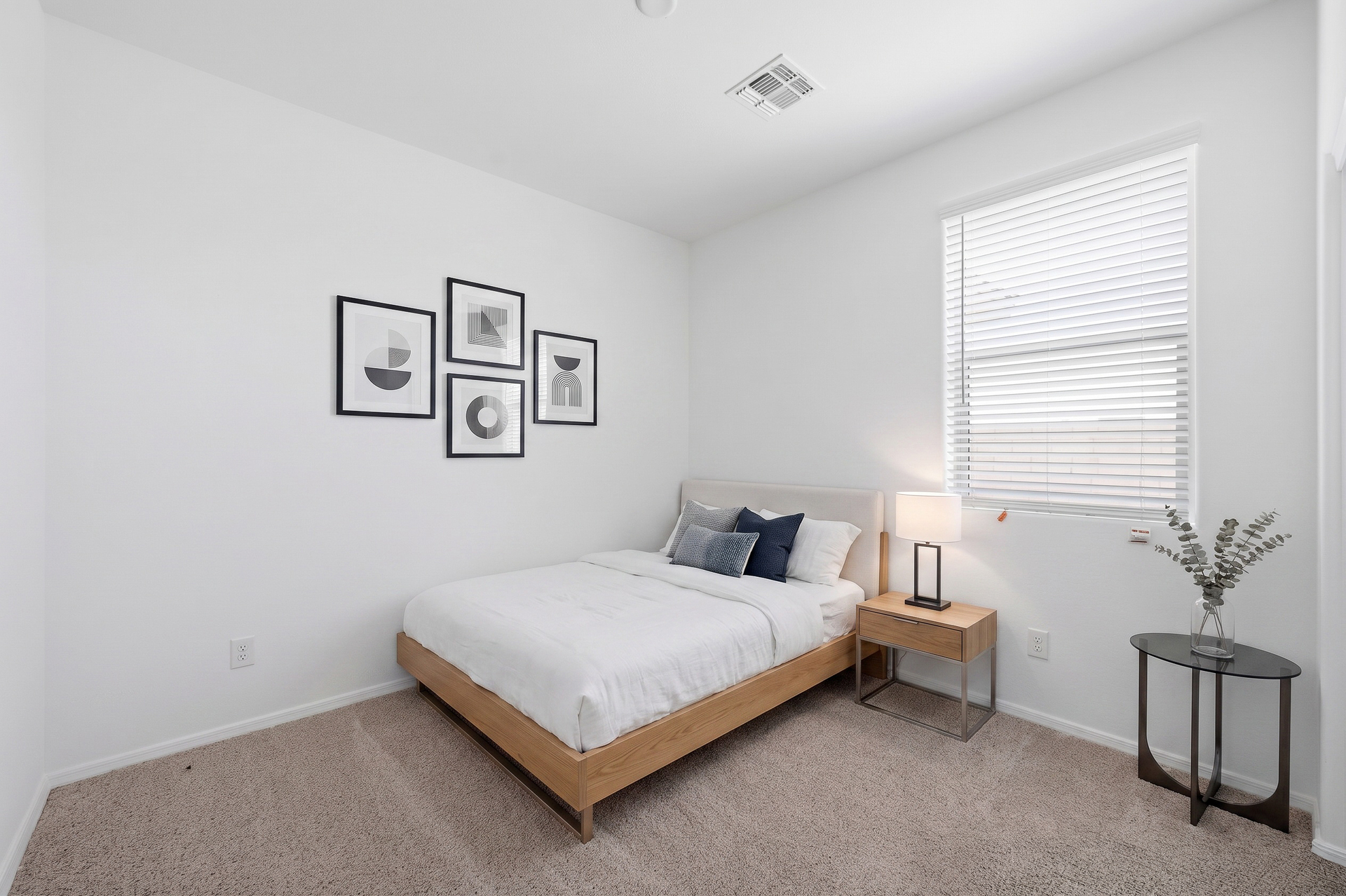 spacious bedroom with full-sized oak bedframe, white duvet, and oak nightstand