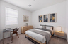 spacious bedroom with large oak bedframe, floating oak nightstand, and large oak dresser