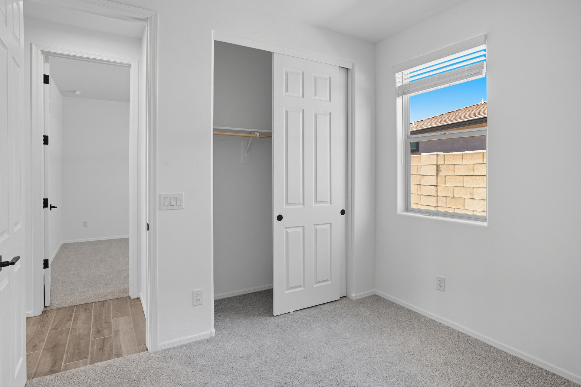 bedroom with light grey carpet and a closet with a sliding door