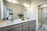 primary bathroom with gray cabinets and tile flooring 