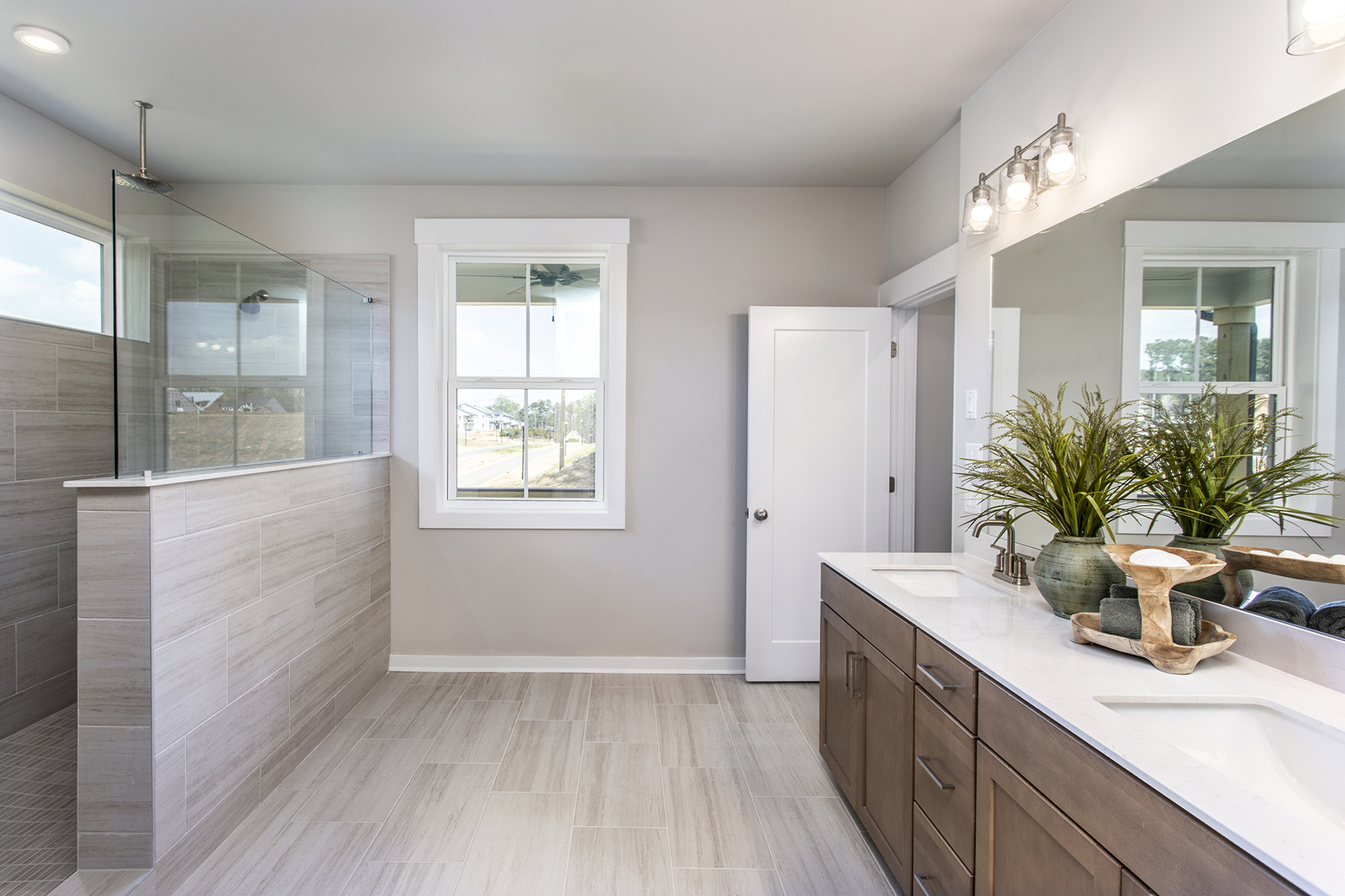 primary bathroom with large walk-in shower and wood-finish cabinets