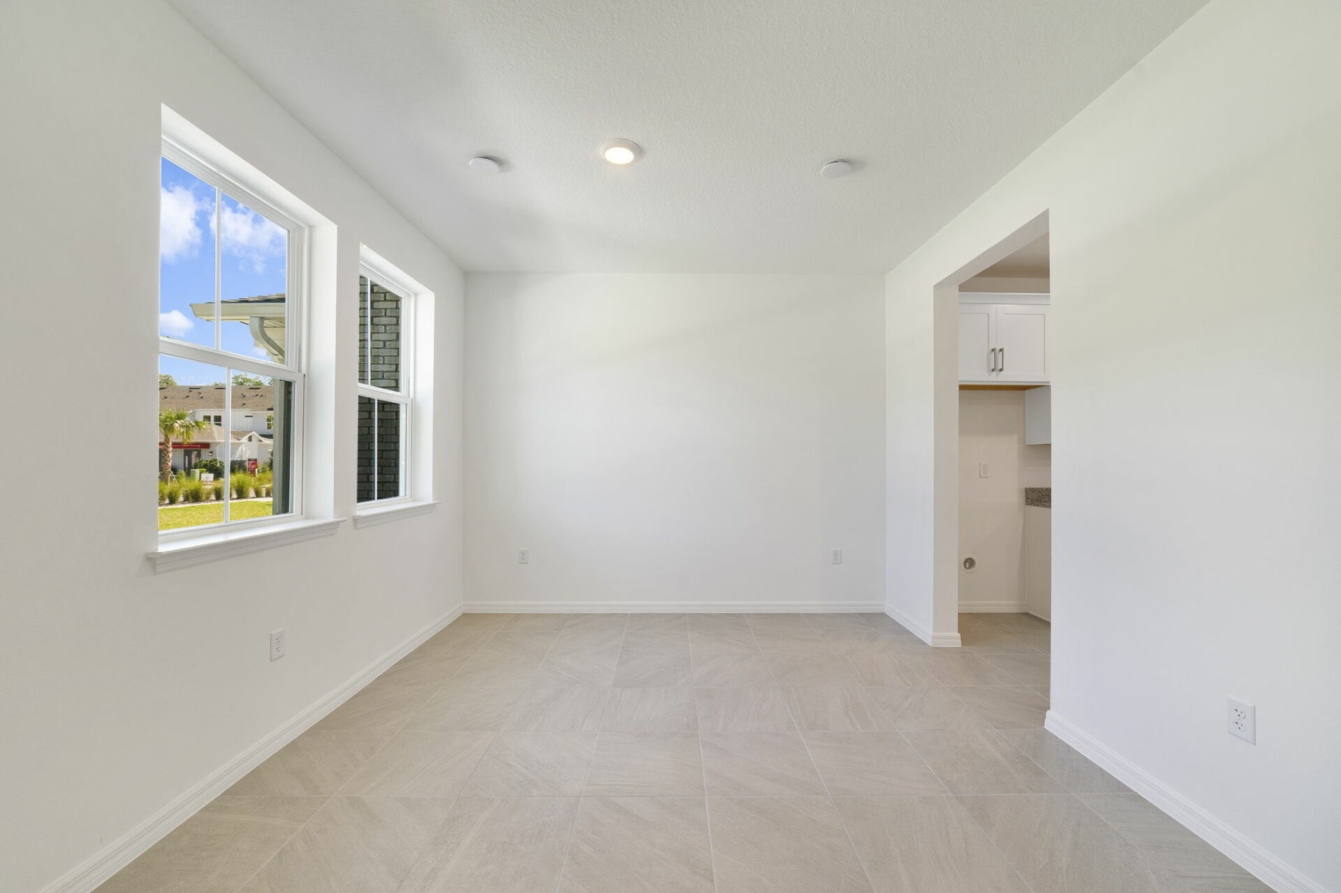 room with large windows and access to the foyer
